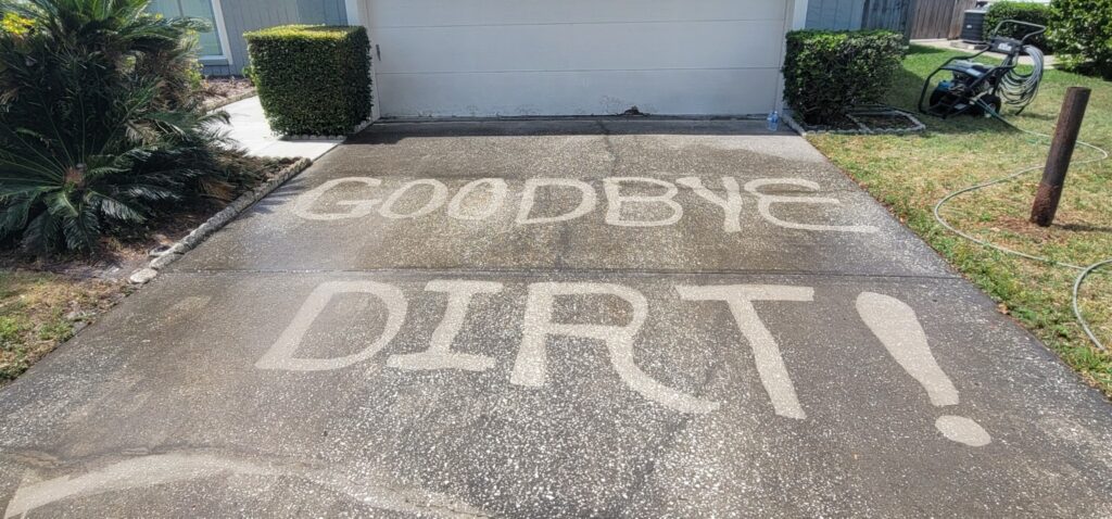 Pressure washing a dirty concrete driveway in Tampa Bay